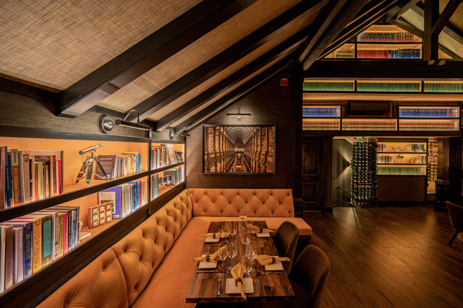 Illuminated bookshelves and a long dining table.