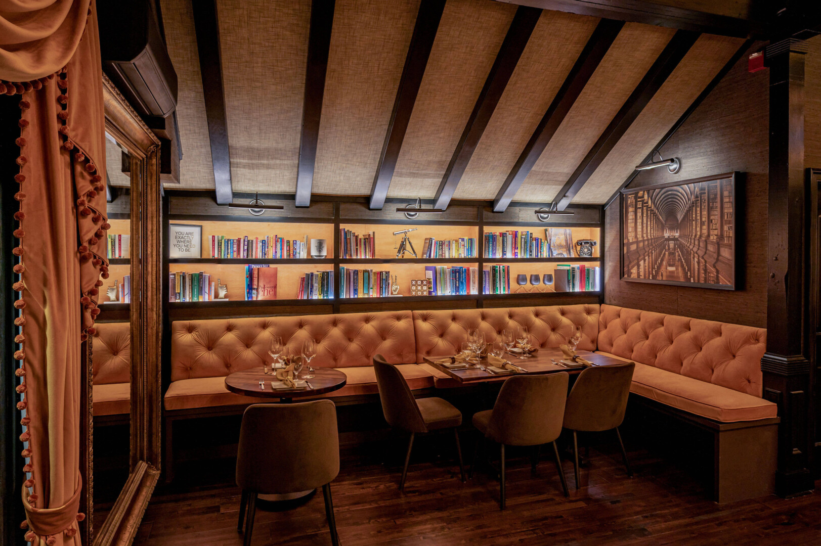 Bistro tables overlooking a wine case and a selection of books.