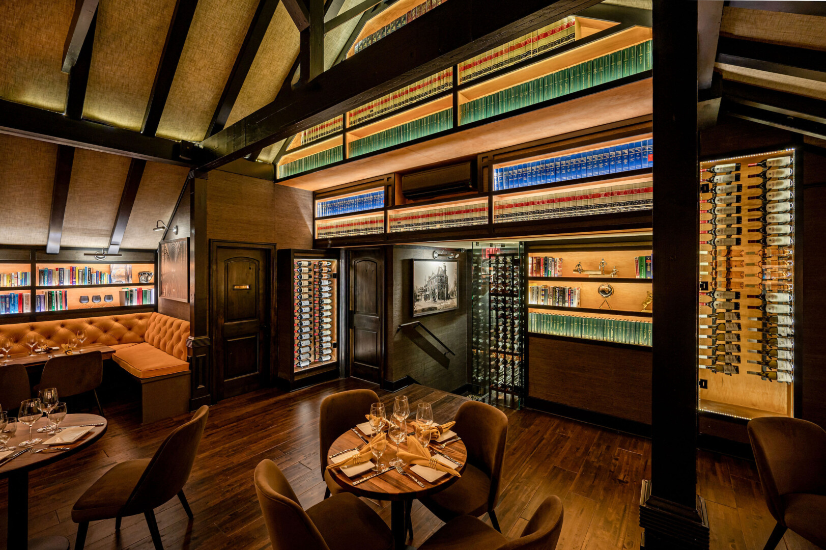 A bistro table looking out at illuminated shelves of books and wine cases.