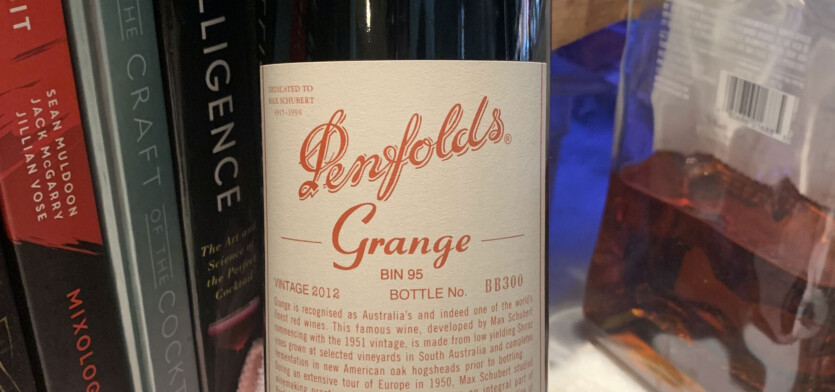 A bottle of Penfolds Grange in front of books.