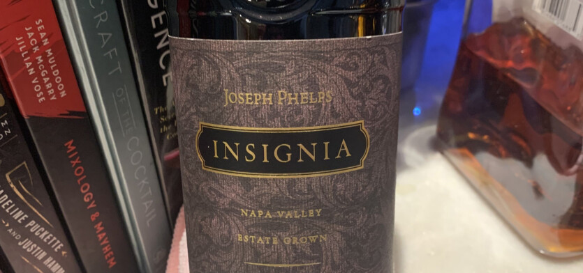 A bottle of Insignia in front of books.